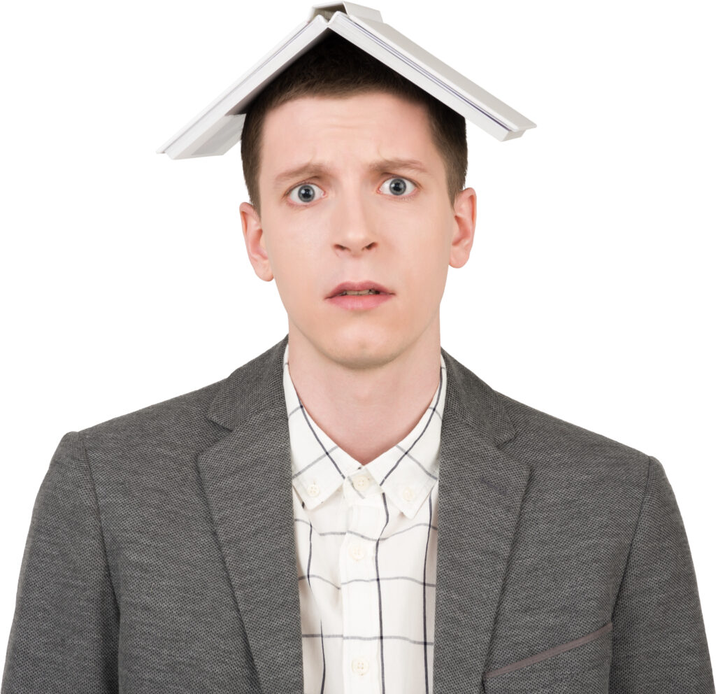 A man with a book on his head and a shocked expression, symbolizing the frustration and overwhelm when a degree doesn't guarantee career success, highlighting the need for skills.