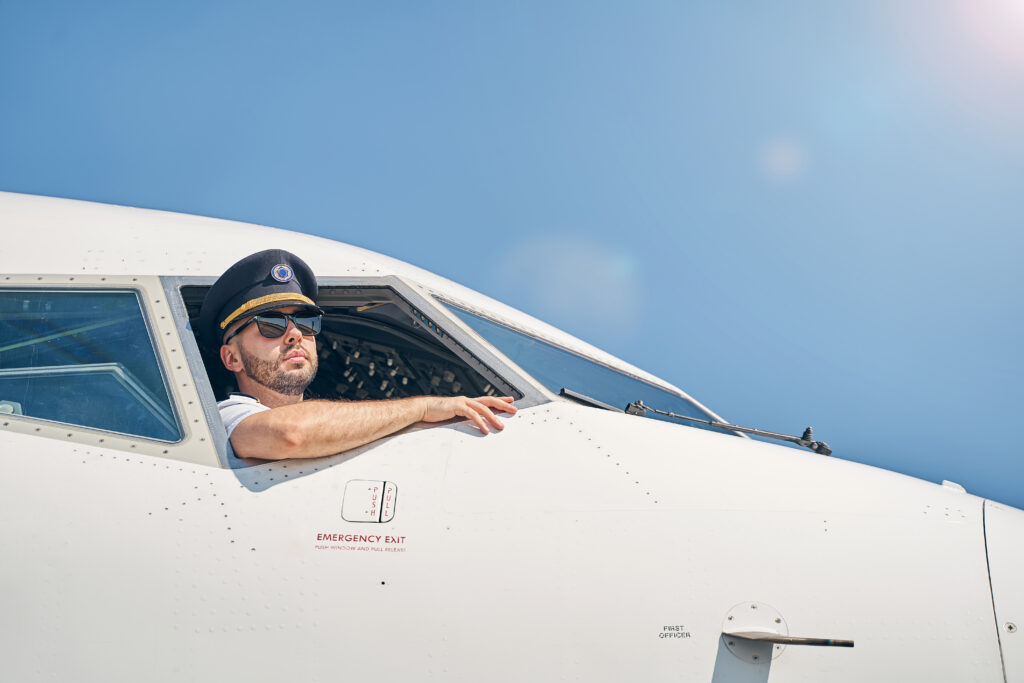 A pilot looking out of the cabin window, symbolizing the importance of letting children choose their own careers and stop forcing kids to be doctors or engineers.