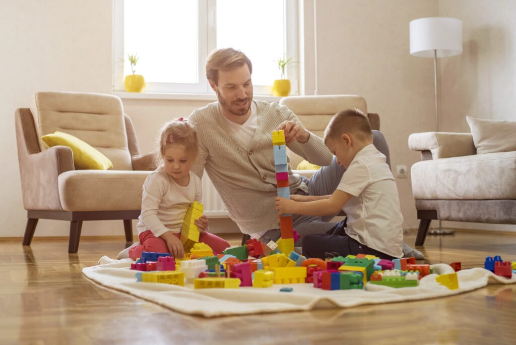 Man playing with his kids, showing that true wealth is health, happiness, and time, not just money