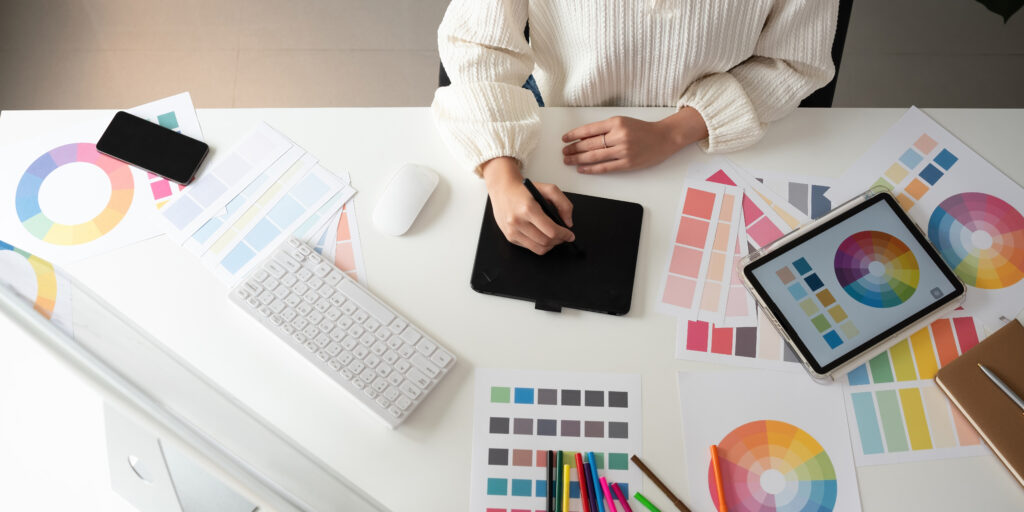 Graphic designer working from home on laptop using beginner design tools..