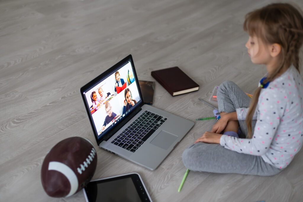 How to learn English – a girl attending group online English classes on her laptop, learning with other students virtually.
