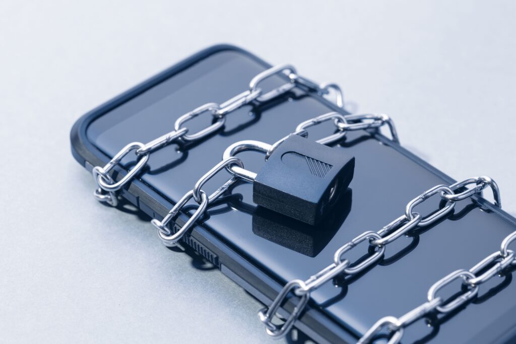 A smartphone locked in chains with a padlock, symbolizing breaking free from smartphone addiction and regaining control over mobile usage.