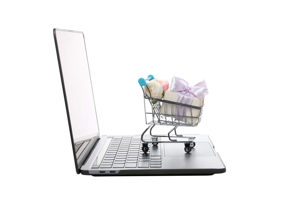 Online marketplace shopping cart icon on laptop representing working from home as a reseller.