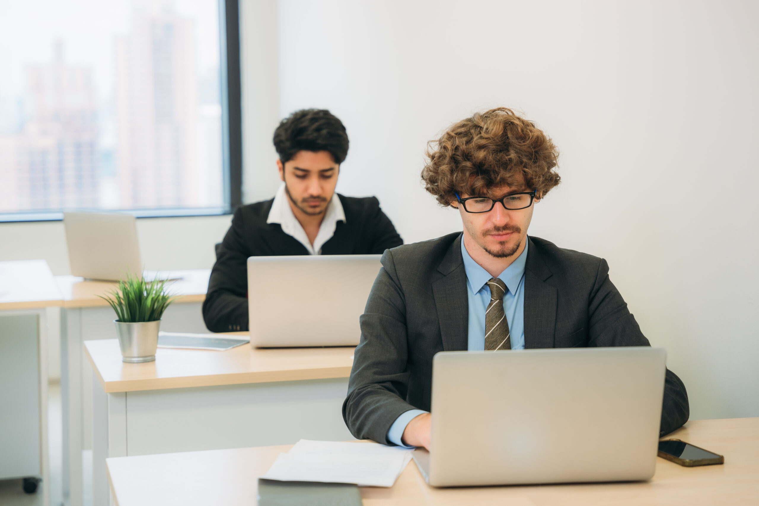 Professional office scene with a diverse team collaborating on laptops for SQL Business Intelligence jobs