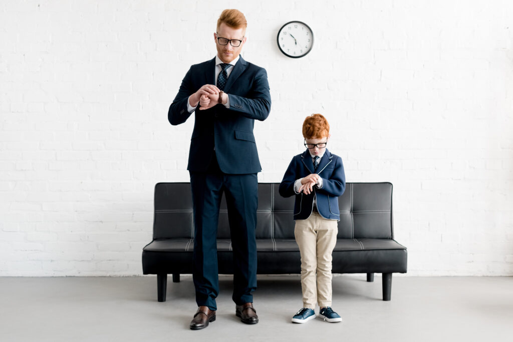 Father and son checking time on their hands, demonstrating ⏰ Screen Time Management for children and balanced daily routines.