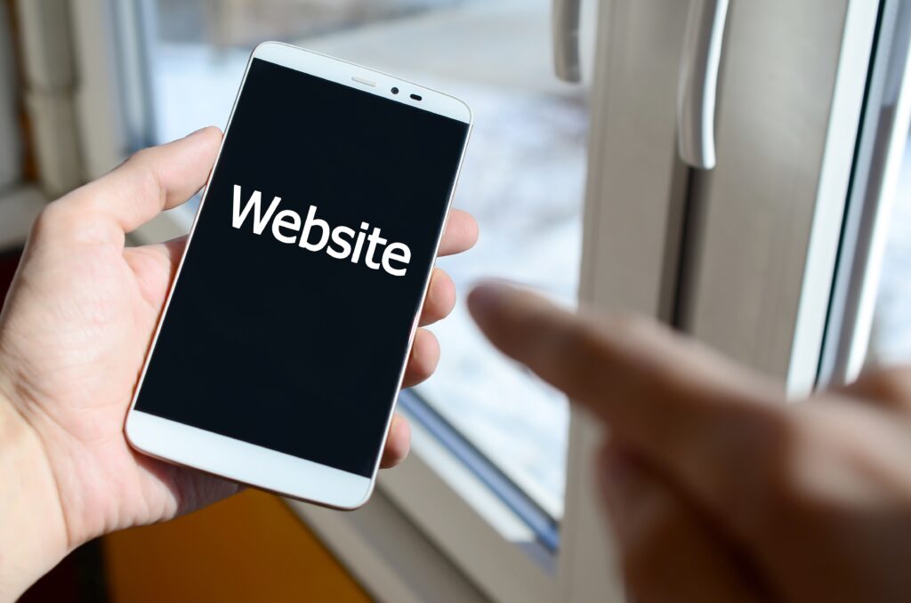 Person working from home testing a website on mobile phone.