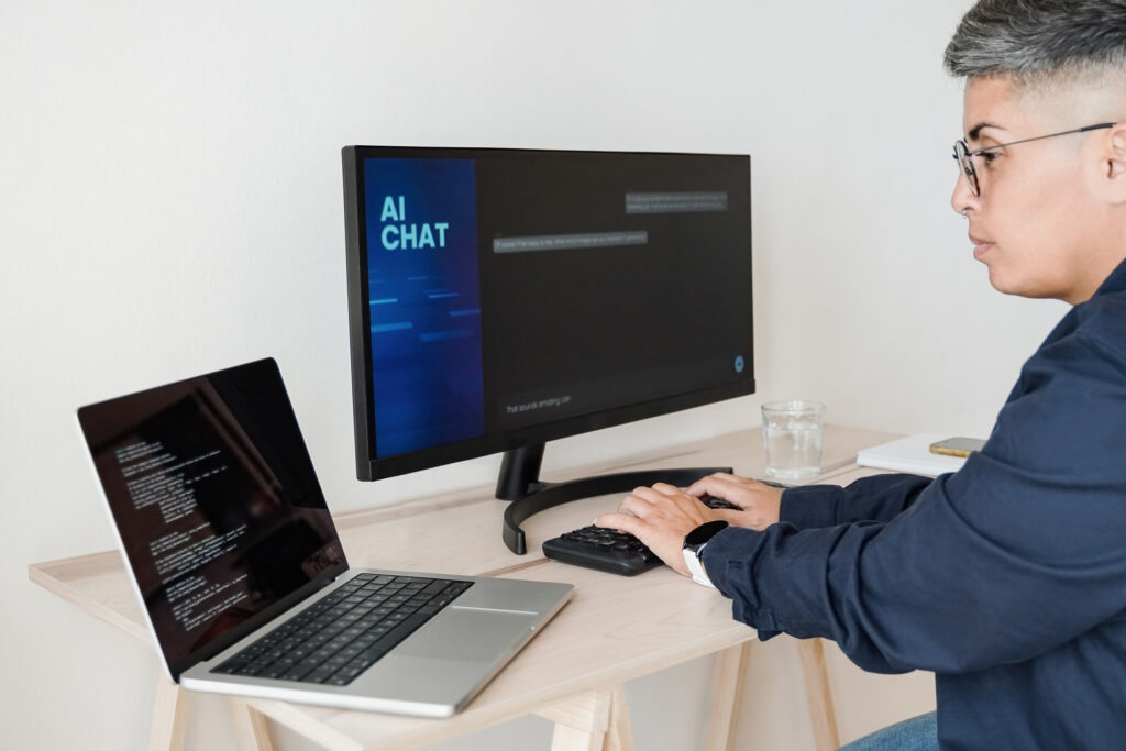 Person using a laptop with an AI chatbot on the screen in a realistic workspace.
