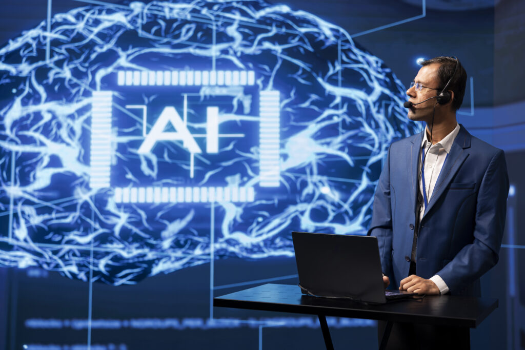 Man teaching an AI class using a laptop and digital tools.