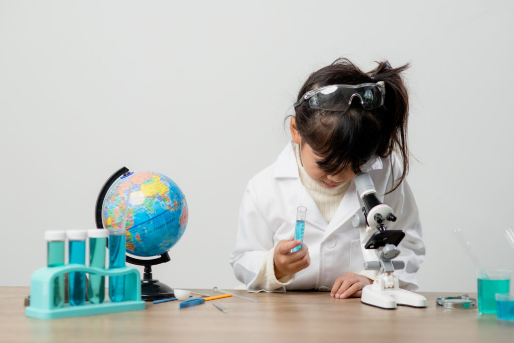 Child looking through a microscope, observing a science experiment, representing curiosity and hands-on learning.