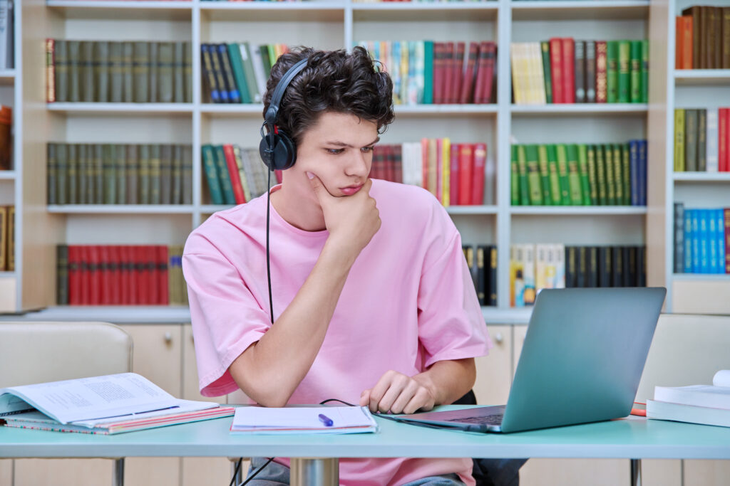 Student studying and learning through YouTube on a laptop and tablet, taking notes and following online lessons, representing digital education and self-paced learning.