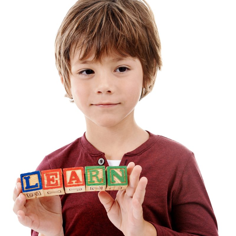 Child carrying the word LEARN, representing education and growth